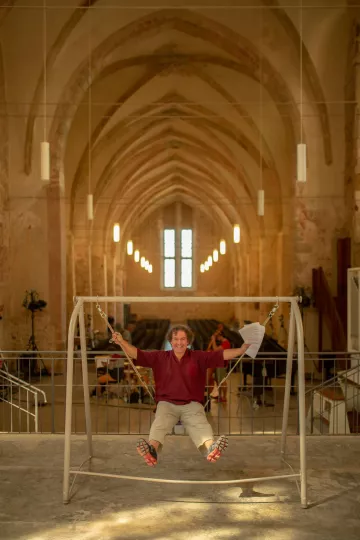 Beat Toniolo sitzt auf einer Hollywoodschaukel im Franziskanerkloster in Zeitz.