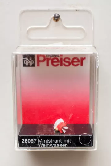 Detailaufnahme einer Preiser Miniaturfigur eines Ministranten mit Weihwasser.