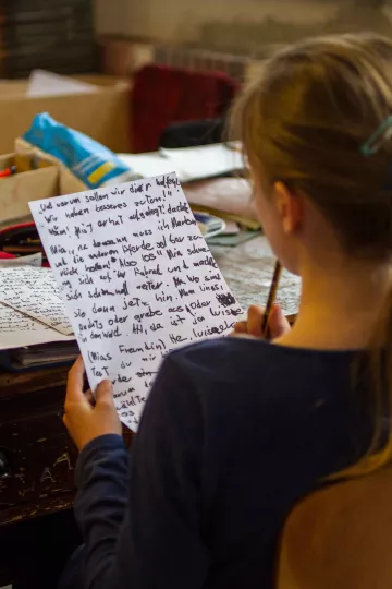 Ein Buchkind liesst ihren Textentwurf für eine Geschichte.