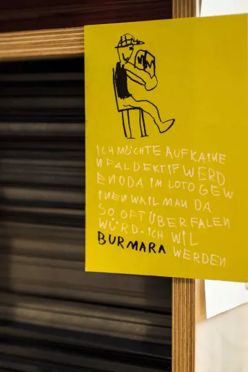 Postkarte an einem Regal der Buchkinder Leipzig.