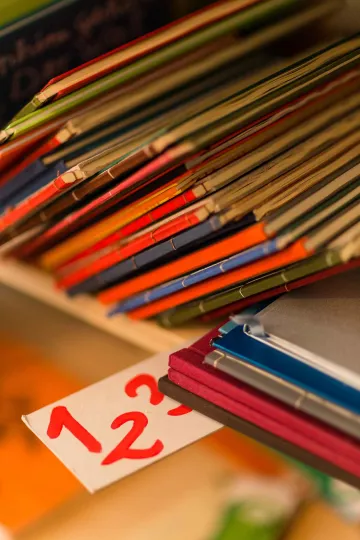 Bücher und Kataloge früherer Produktionen der Buchkinder sind in mehreren Regalen zu finden.