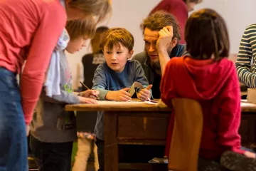 Ein alter Holztisch bildet das Zentrum der Werkstatt.
