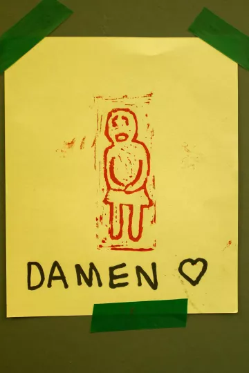 Beschilderung der Damen-Toilette in der Werkstatt der Buchkinder Leipzig.