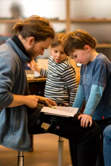 Buchkinder und Betreuer besprechen eine Geschichte.