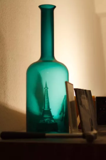 Eine optische Täuschung lässt den Miniatur-Eifelturm in einer Flasche erscheinen.