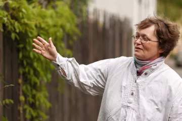 Christina Weiß vor dem Zaun des Hauses in Leipzig Lindenau in dem sie lebt.