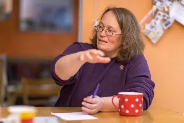 Christina Weiß sitzt an einem Tisch in ihrer Wohnung in der Roßmarktstraße.