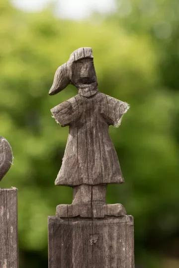 Detailaufnahme einer handgeschnitzten Figur im Zaun vor dem Haus in der Roßmarktstraße in Leipzig Lindenau.