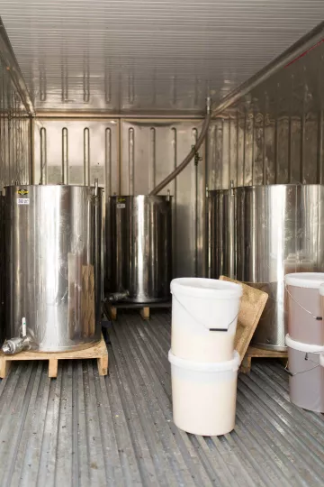 Im Inneren eines Lagerraums, in dem grpße Metallfässer aufbewahrt werden.