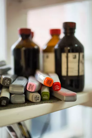 Glasflaschen und Stifte in einem Regal in Eva Walkers Atelier in Leipzig Plagwitz.