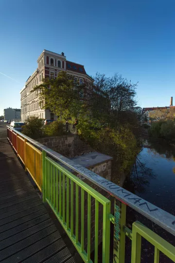 Eine Brücke als Wegeverbingung, die Fußgängerbrücke über den Karl-Heine-Kanal, die die beiden Teile der Aurelienstraße miteinander verbindet. Seit Herbst 2015 regenbogenfarben angesprüht