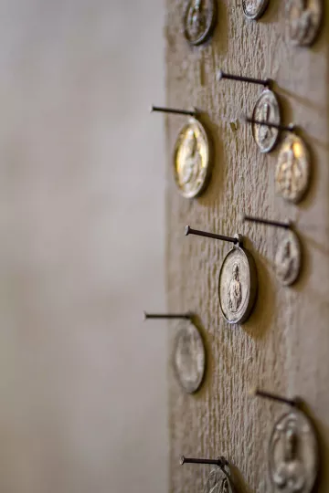 Münzen bzw. Heiligenbilder an eine Wand genagelt.