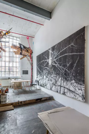 Blick auf den zentralen Bereich des Ateliers, mit Sitzecke im Hintergrund.